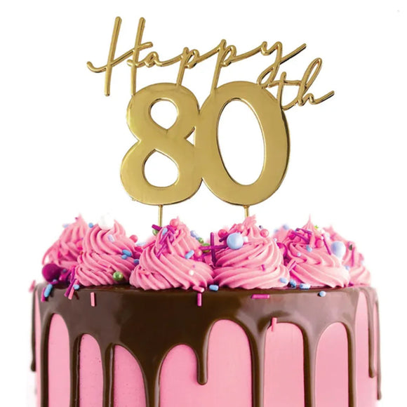 Cake Craft Happy 80th Gold Metal Cake Topper placed on a pink cake with chocolate cake drip