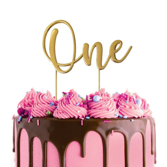 Cake Craft One Gold Metal Cake Topper placed on a pink cake with chocolate cake drip