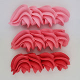 buttercream colour examples of the coral pink gel colour on a white background