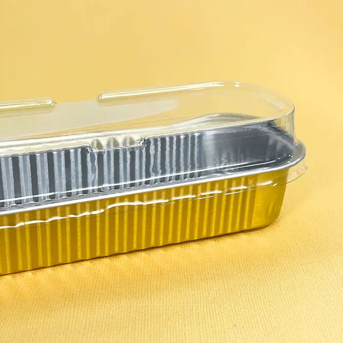 gold foil rectangle baking cup tray with plastic dome lid on a yellow background