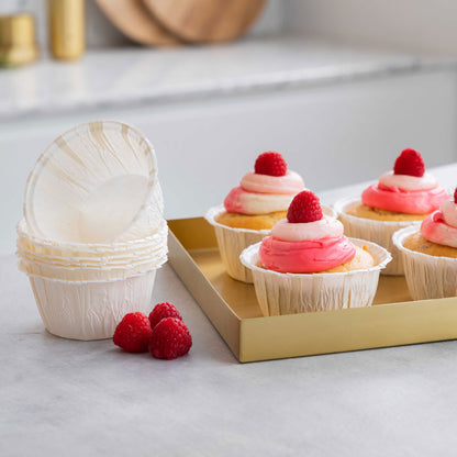 small white baking cups with raspberries and desserts