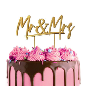 Cake Craft Mr & Mrs Gold Metal Cake Topper placed on a pink cake with chocolate cake drip
