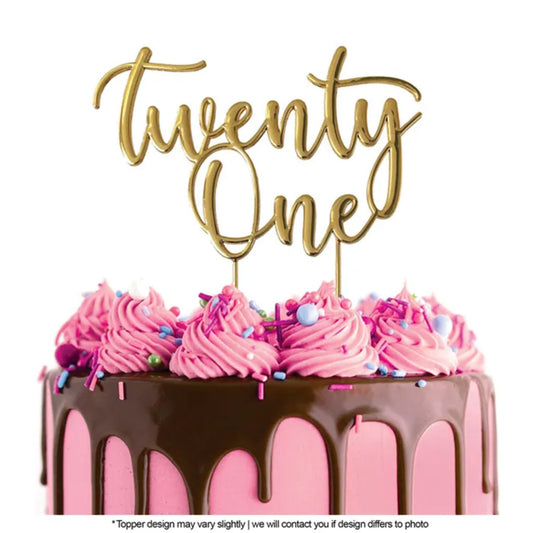Cake Craft Twenty One Gold Metal Cake Topper placed on a pink cake with chocolate cake drip