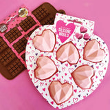 mini chocolate block and 3d geo heart silicone moulds laid together on a pink background