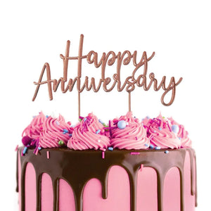 Cake Craft Happy Anniversary Rose Gold Metal Topper placed on a pink cake with chocolate brown cake drip and scattered with sprinkles