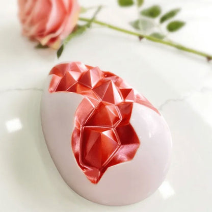 pink geode Easter egg beside rose on marble background