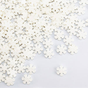 pearl white snowflake candy shapes sprinkles scattered on a white background