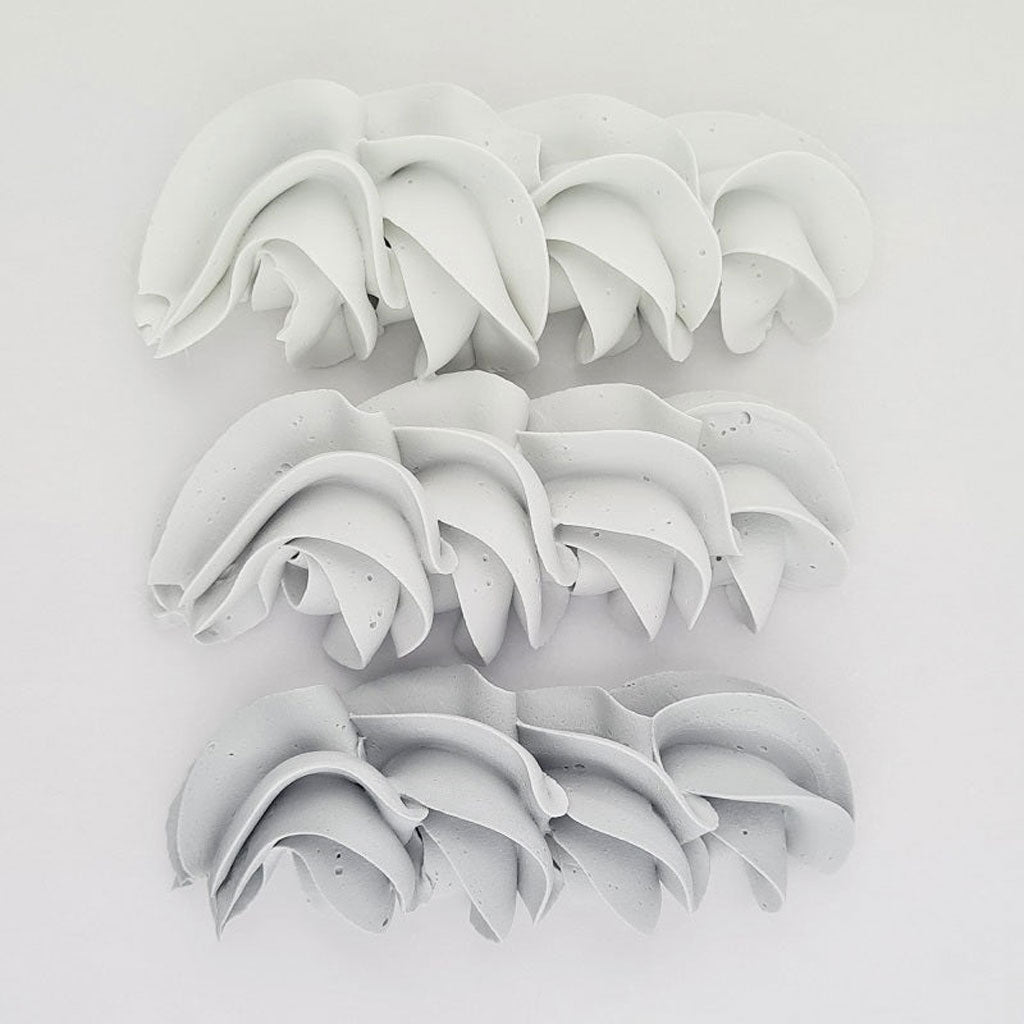 buttercream colour examples of the concrete grey gel colour on a white background