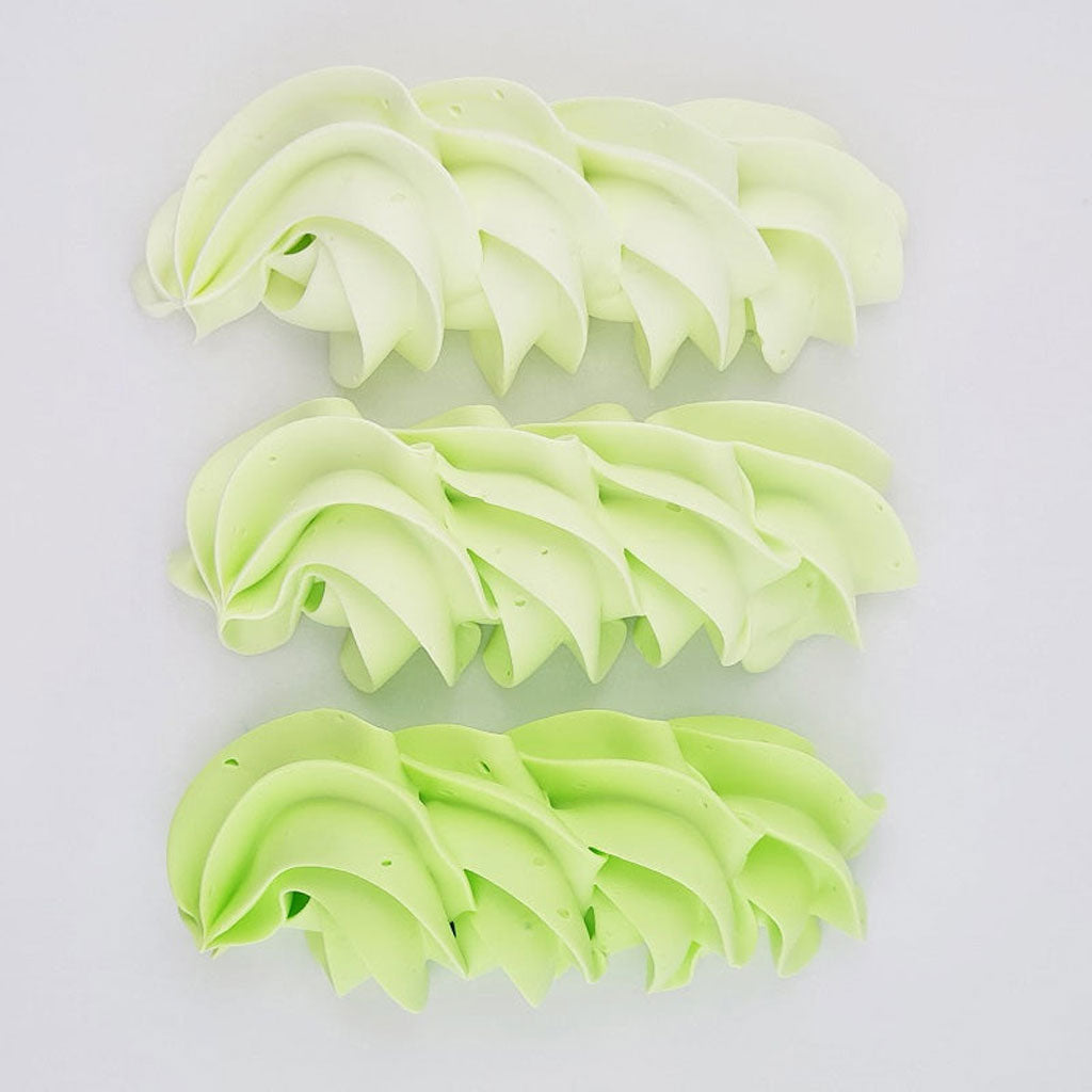 buttercream colour examples of the green apple gel colour on a white background