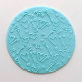 hearts and arrows pattern from debosser on round circle of blue icing